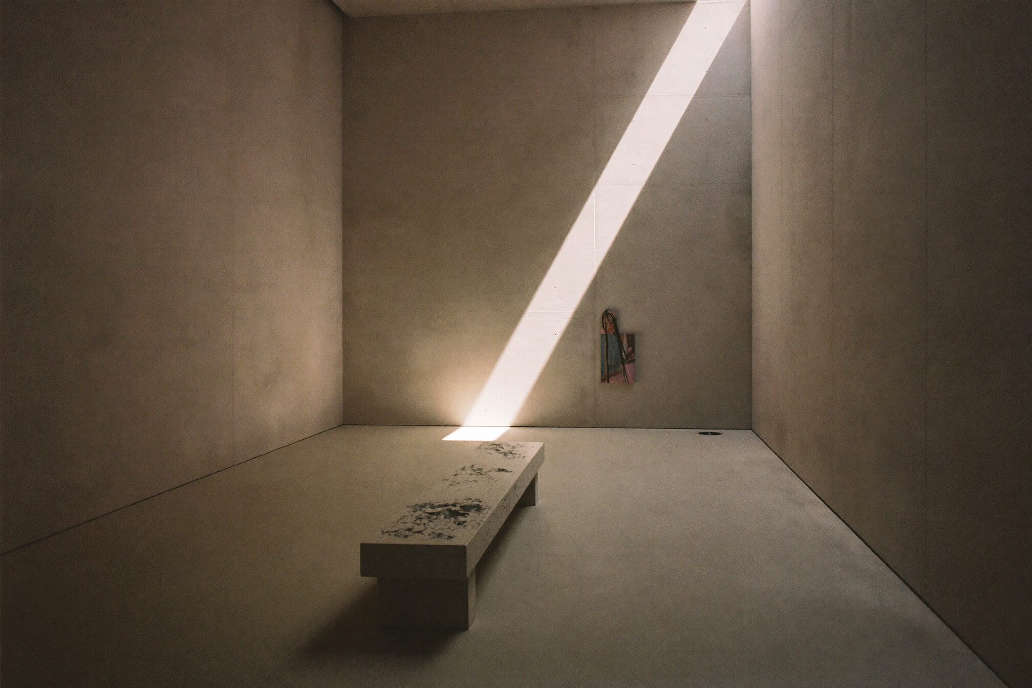 Concrete gallery hall with a diagonal shaft of daylight
