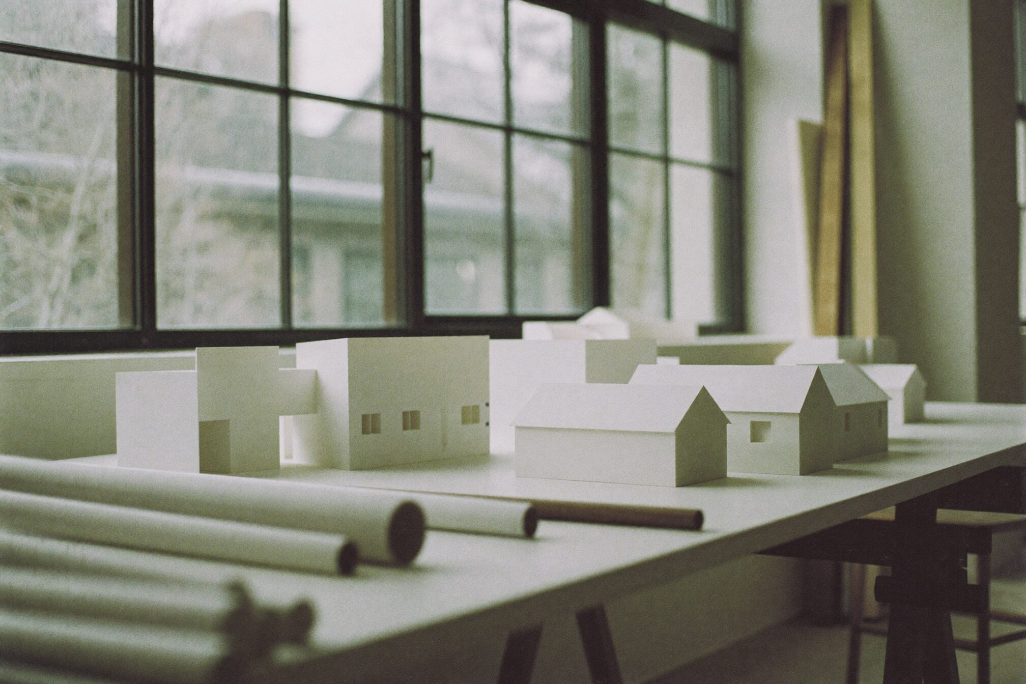 Worktable with white architectural models in daylight